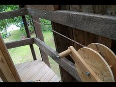 a close up of a wooden spool on a porch with chains hanging from it