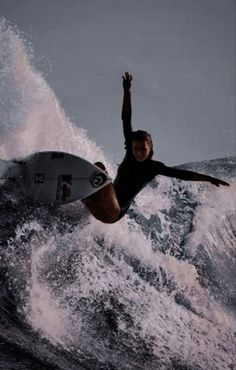 a man riding a wave on top of a surfboard