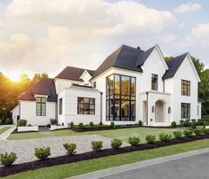 a large white house sitting on top of a lush green field