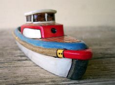 a small toy boat sitting on top of a wooden table