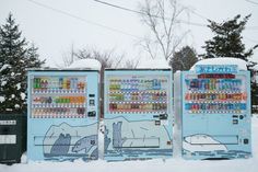 two vending machines covered in snow next to each other with drinks and beverages on them