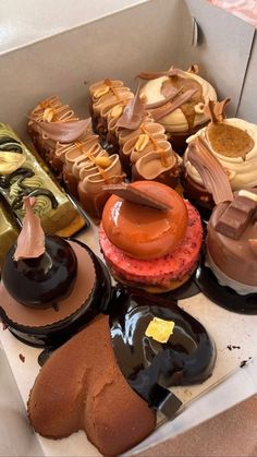 a box filled with lots of different types of cakes and pastries on top of each other