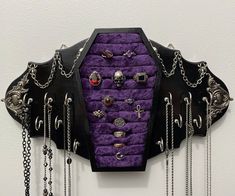 a purple and black wall hanging with chains on it's sides, attached to a white wall