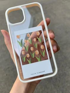 a person holding up a phone case with flowers on it