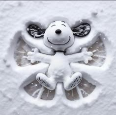 a snoopy snow decoration on the side of a building in the snow with it's eyes closed