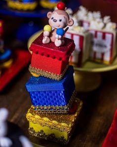 there is a small toy monkey sitting on top of some colorful boxes in the shape of bricks