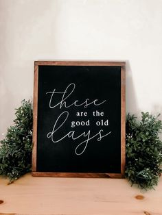 there are the good old days written in white on a blackboard next to some greenery