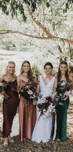 a group of women standing next to each other in front of a tree with flowers