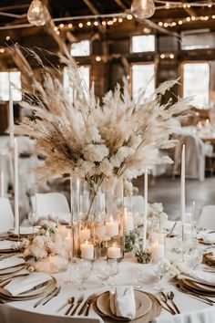 an elegant table setting with white flowers and candles