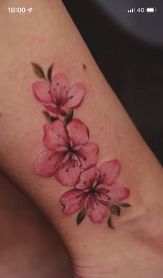 a pink flower tattoo on the ankle