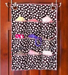 a polka dot wall hanging organizer with cupcakes and other items on it in front of a wooden door