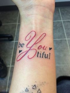 a woman's wrist with the words be you tiful written on it and hearts