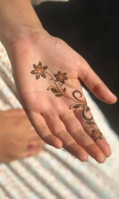 a woman's hand with flowers painted on it