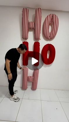 a man standing in front of a large sign that says ohoh with red and white stripes