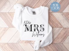 a white sweatshirt with the words,'future mrs williams'on it sitting on a wooden floor