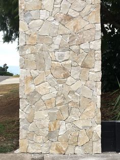 a tall stone pillar sitting next to a lush green field