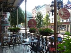 an outdoor restaurant with tables and chairs on the outside patio, surrounded by potted plants