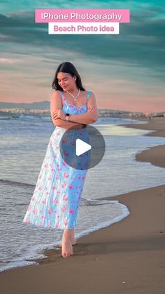 a woman standing on top of a beach next to the ocean with her arms crossed