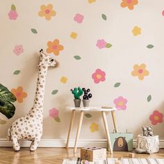 a child's room with a giraffe and flower wall decals on the walls