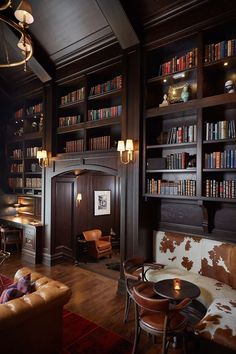 a living room filled with lots of furniture and bookshelves covered in bookcases