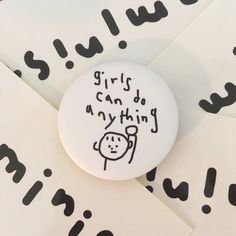 a button with the words girls can do anything written on it in black and white