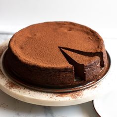 a chocolate cake on a plate with one slice missing from it's center piece