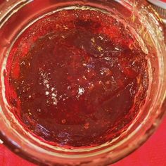 a glass jar filled with red liquid sitting on top of a table