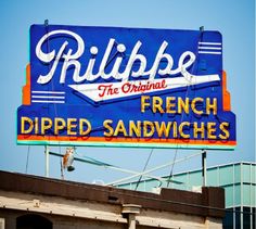 a large blue sign on the side of a building that reads rilbbe, the original french dipped sandwiches