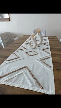 the table is set with two white vases on it