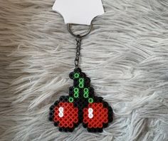 a keychain made out of legos with two cherries on it's side