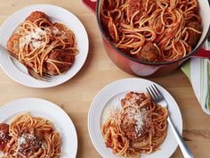 three plates of spaghetti with meatballs and parmesan cheese on the side next to a pot of tomato sauce