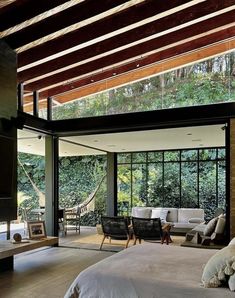 a bedroom with large windows and wooden ceiling