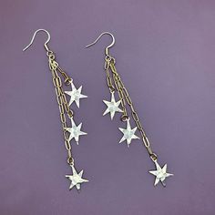 These gold earrings have varying lengths of chain with small irregular stars dangling from each strand. The textured stars are very lightweight and made of brass. Approx. 4"Hammered star charms are lightweight brass. The chain and ear hooks are made of stainless steel. -------------- 🔨 I stamp each letter/design by hand with traditional tools so each item is truly one of a kind. This also means your piece won’t look exactly as pictured. Due to the nature of stamping there may be a slight impres Star-shaped Metal Earrings With Dangling Charms, Star-shaped Metal Jewelry With Dangling Charms, Brass Dangle Jewelry With Star Charm, Star Earrings Dangle, Stamp Letter, Semi Permanente, Earring Pins, Heart Dangle Earrings, Letter Design