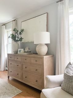 a living room filled with furniture and a large mirror on top of a wooden dresser