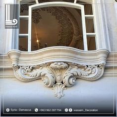 an ornate window frame on the side of a building with columns and windowsills