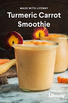 two glasses filled with carrot smoothie on top of a table