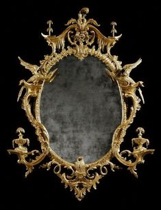 an ornate gold framed mirror against a black background