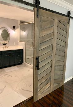 an open sliding door in a bathroom with wood flooring and marble counter top area