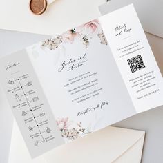 an open wedding card with flowers on it