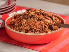 a bowl filled with granola sitting on top of a red and white table cloth