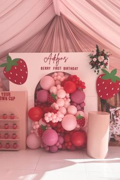 a strawberry themed birthday party with balloons and decorations