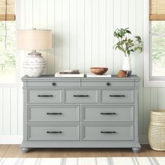 a gray dresser in a room with white walls