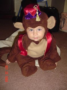 a baby in a monkey costume sitting on the floor