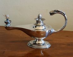 a silver teapot sitting on top of a wooden table