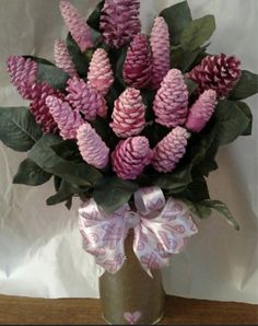 a vase filled with pink flowers and green leaves