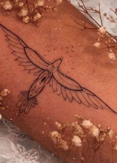 a tattoo on the back of a woman's arm with a bird flying over it