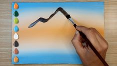 a person is painting an image with watercolors