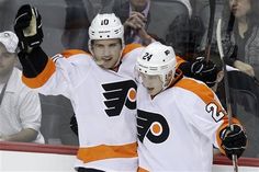 two hockey players are congratulating each other on the ice as fans look on