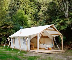 a white tent in the middle of a forest