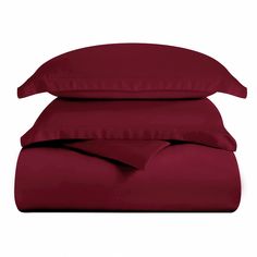 the burgundy sheets and pillow cases are stacked on top of each other